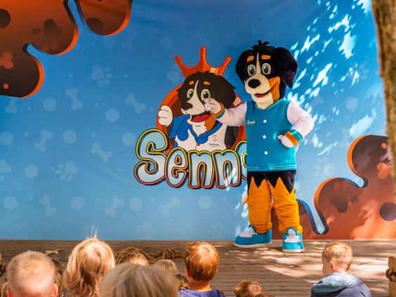 Kinderen kijken naar een live show van de mascottes Senn & Pien op het podium van Parc Heihaas.