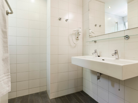 De functionele badkamer in een cottage van Parc Heihaas, voorzien van een wastafel en douche.
