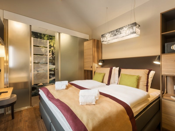 De luxe slaapkamer van een VIP cottage in Center Parcs Park Allgäu, met een stijlvol opgemaakt tweepersoonsbed, moderne verlichting en een chique uitstraling.