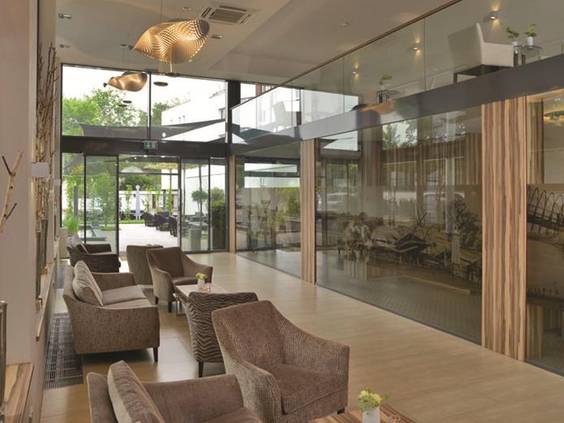 De lichte en moderne lobby van het Parkhotel in Oberhausen, met comfortabele zitjes voor het hele gezin.
