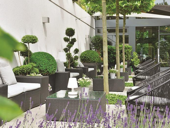 De prachtig aangelegde en groene hoteltuin van Parkhotel Oberhausen, een oase van rust voor families.