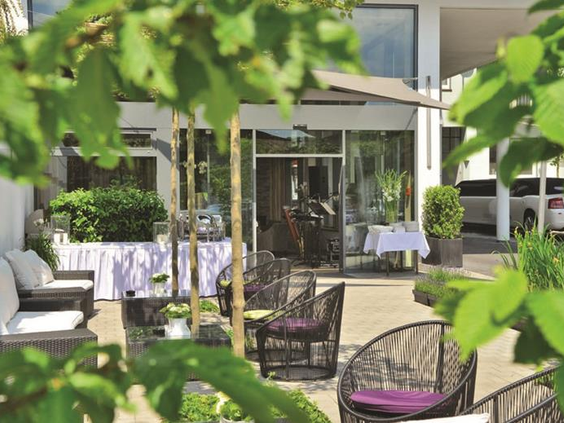 Het ruime en groene buitenterras van Parkhotel Oberhausen, een ideale plek voor gezinnen om te ontspannen.