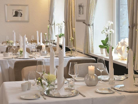 Een elegant gedekte tafel in het restaurant van Parkhotel Oberhausen, klaar voor een sfeervol familiediner.