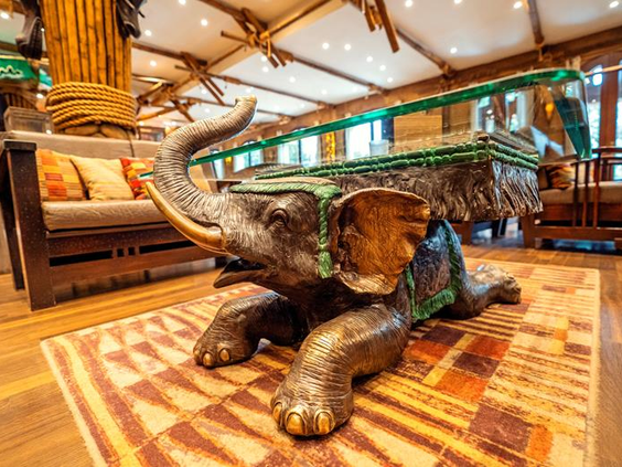 Uniek interieur van themahotel Ling Bao in Phantasialand, met een grote salontafel in de vorm van een bronzen olifant.