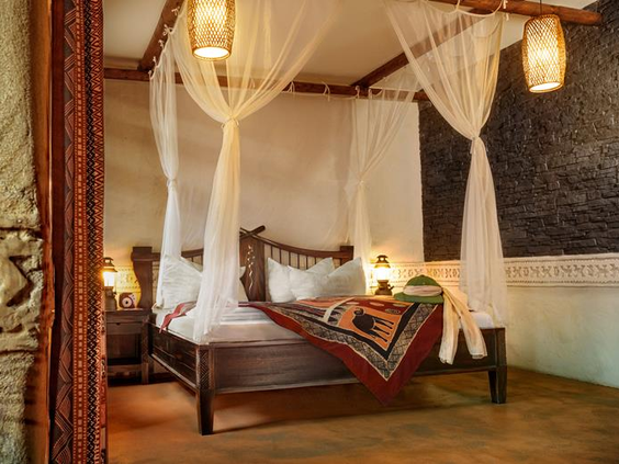 Sfeervolle hotelkamer in Hotel Matamba in Phantasialand, met een donkerhouten hemelbed met klamboe in Afrikaanse stijl.