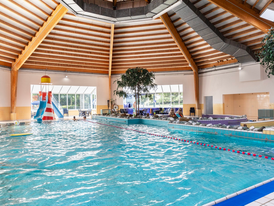 Het overdekte zwembad van Vakantiepark Port Greve in Zeeland, met een grote waterglijbaan en een apart peuterbad.