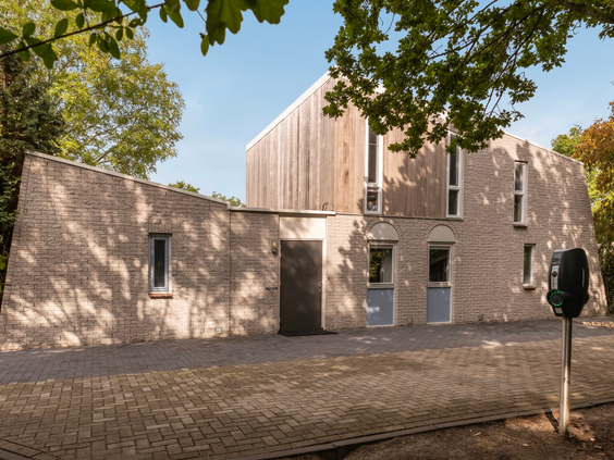 De moderne buitenkant van een nieuw vakantiehuis op Vakantiepark Port Greve in Zeeland, met een eigen laadpaal voor elektrische auto's.
