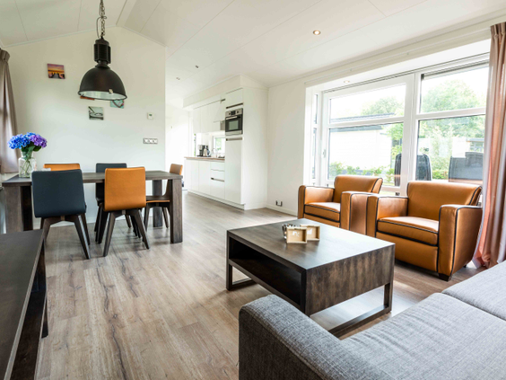 De open keuken, eethoek en zithoek in een van de modern ingerichte vakantiewoningen op Recreatiepark Het Esmeer.