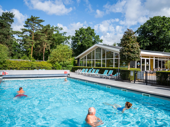 Het verwarmde buitenzwembad van Recreatiepark 't Gelloo op een zonnige dag.