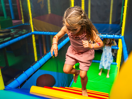 Meisje springt op een zachte ondergrond in de indoor speeltuin van Recreatiepark 't Gelloo.