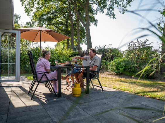 Gasten genieten van een gezellige barbecue op het terras van hun vakantiewoning op Residence Lichtenvoorde.