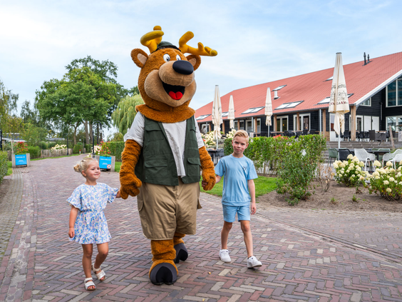 Mascotte Toppe Bob wandelt over het park met enthousiaste kinderen op Residence Lichtenvoorde.