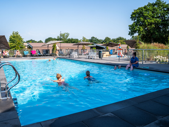 Kinderen zwemmen in het grote buitenzwembad van Residence Lichtenvoorde tijdens een zonnige zomerdag.