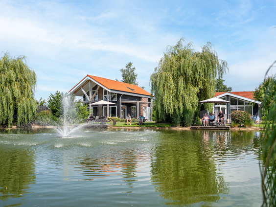 Prachtig uitzicht over de vijver met fontein en omliggende vakantiewoningen op Residence Lichtenvoorde.