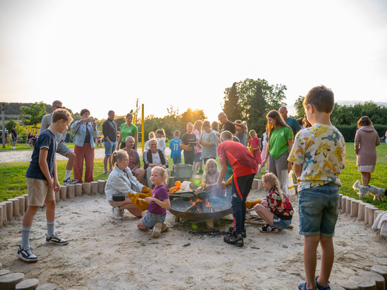 Kinderen zitten gezellig rondom een vuurkorf tijdens een georganiseerde buitenactiviteit op Residence Valkenburg.