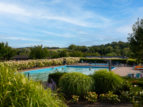 Het verwarmde buitenzwembad van Residence Valkenburg met een prachtig panoramisch uitzicht over de Limburgse heuvels.
