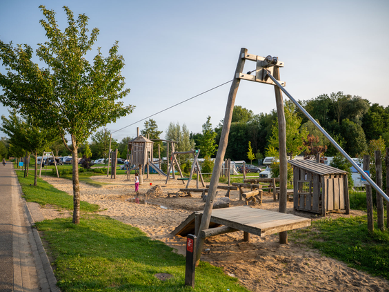 Een kind zoeft naar beneden op de kabelbaan in de buitenspeeltuin van Residence Valkenburg.