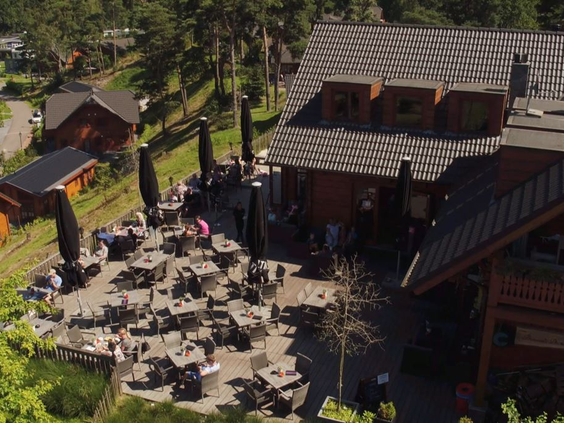 Het grote en zonnige terras van de brasserie op Resort Brunssummerheide, waar gasten genieten van een hapje en een drankje met uitzicht.