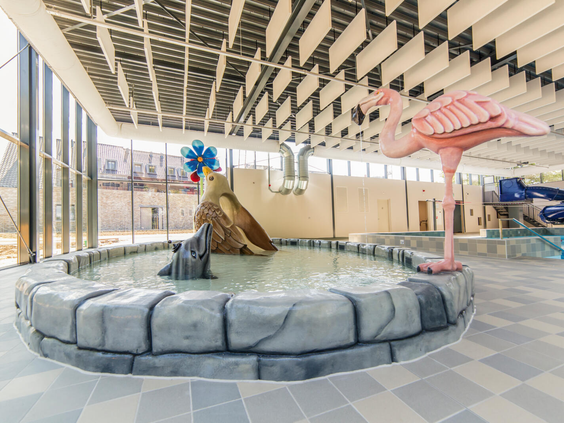 Het vrolijke kinderbad in het zwemparadijs van Dormio Resort Maastricht met een grote roze flamingo en leuke speelelementen.