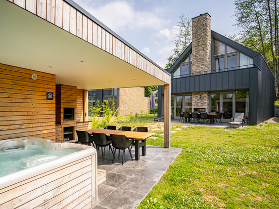 Een luxe, moderne wellness-vakantiewoning op Dormio Resort Maastricht met een groot overdekt terras, buitenkeuken en een eigen jacuzzi in de tuin.
