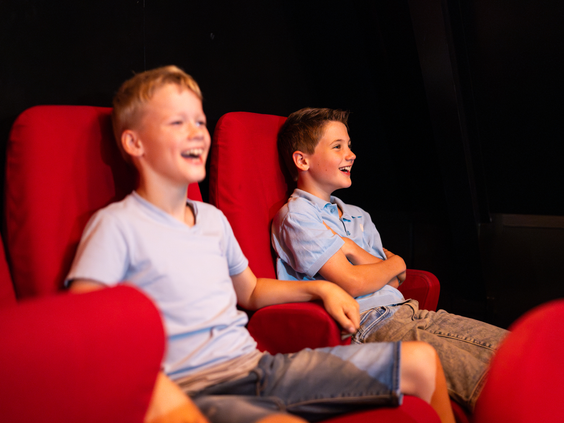 Twee jongens kijken een film met 3D-brillen in de bioscoop van Resort Veluwe.