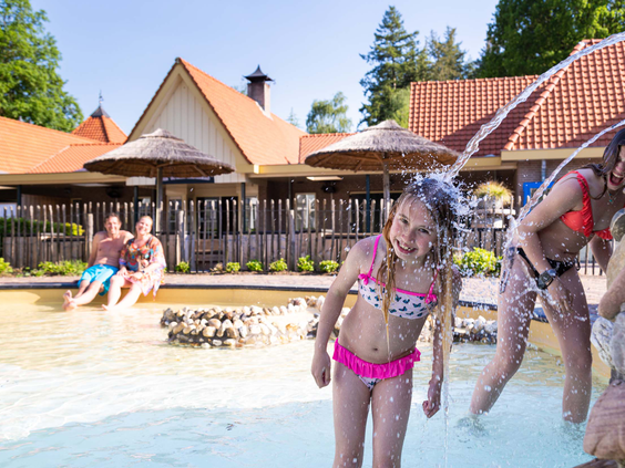 Lachend meisje in zwemkleding bij het waterspeelparadijs op Resort Veluwe