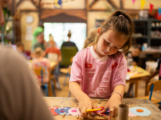 Meisje is geconcentreerd aan het knutselen bij de Kids Club van Topparken