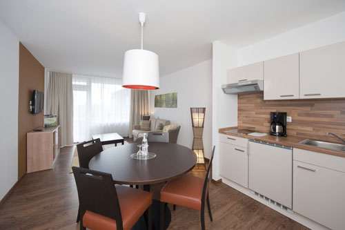 De moderne eethoek en kitchenette in een van de ruime familie-appartementen van het Rhön Park Hotel.