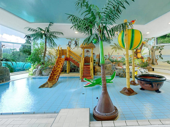 Het gethematiseerde kinder- en peuterbad in het zwemparadijs van Rhön Park Hotel, met palmbomen, kleine glijbanen en waterspeeltjes.