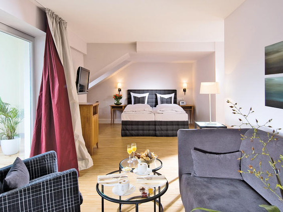 Een ruime en modern ingerichte suite onder het dak van Romantik Jugendstilhotel Bellevue, met een comfortabel bed en een gezellige zithoek.