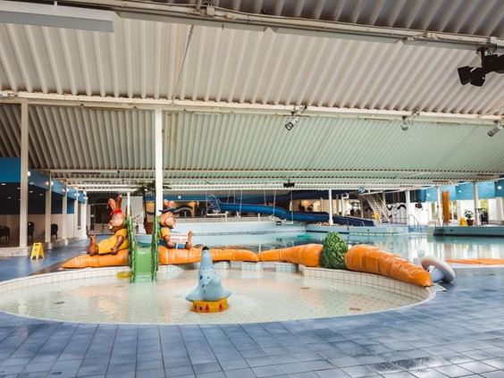 Het kleurrijke kinderbad in het subtropische zwemparadijs van Roompot, met een wortel-thema en diverse waterspeeltoestellen.
