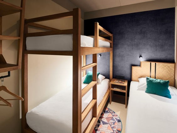 Slaapkamer voor de kinderen met een houten stapelbed en een apart eenpersoonsbed in het Safari Hotel.