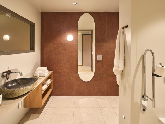 Mindervalide badkamer in het Safari Hotel Beekse Bergen met een verlaagde wastafel en steunen bij het toilet.