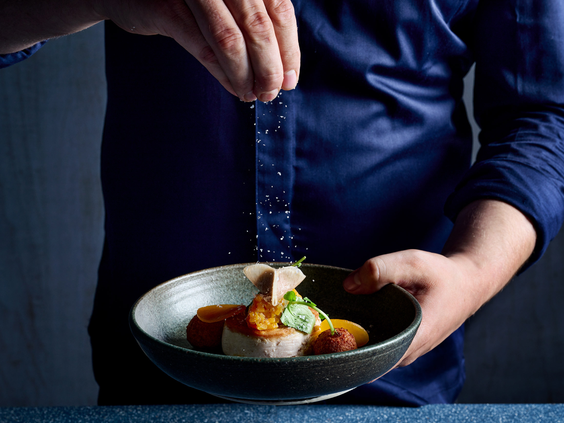 Een chef bereidt een culinair gerecht in restaurant Moto van het Safari Hotel Beekse Bergen