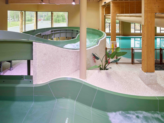 Groene waterglijbaan in her overdekte zwembad van kindvriendelijk vakantiepark Safari Resort Beekse Bergen met bochten met uitzicht op het buitengebied