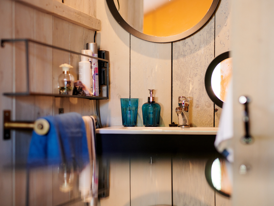 De moderne en luxe badkamer in een safaritent op Sallandshoeve, met een wastafel, spiegel en stijlvolle details.