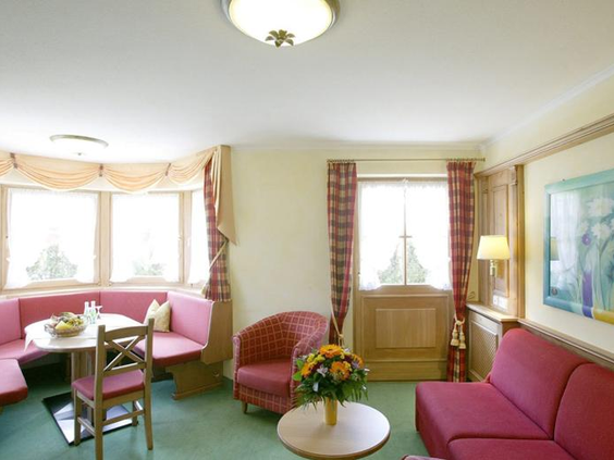 De gezellige woonkamer van een familieappartement in Sonnhofs Ferienresidenz, met een ruime zithoek en een traditionele eethoek.