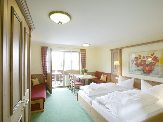 Overzicht van een ruim familieappartement in Sonnhofs Ferienresidenz, met bedden, een eethoek en veel leefruimte.