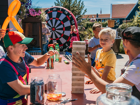 Kind speelt een spannend spel met het animatieteam tijdens een zonnige middag op Strandpark De Zeeuwse Kust, vol plezier en vermaak.
