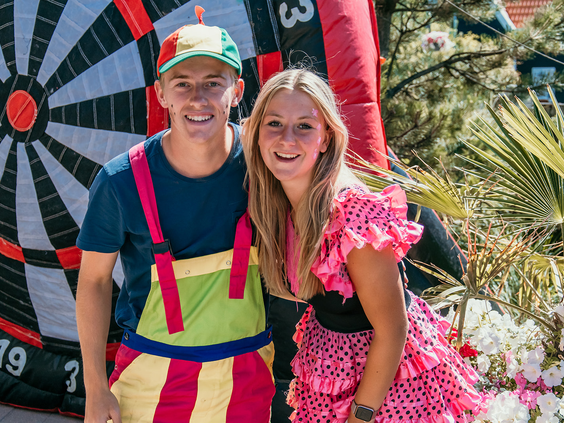 Twee vrolijke medewerkers van het animatieteam van Strandpark De Zeeuwse Kust poseren voor een foto, klaar om de kinderen te vermaken.