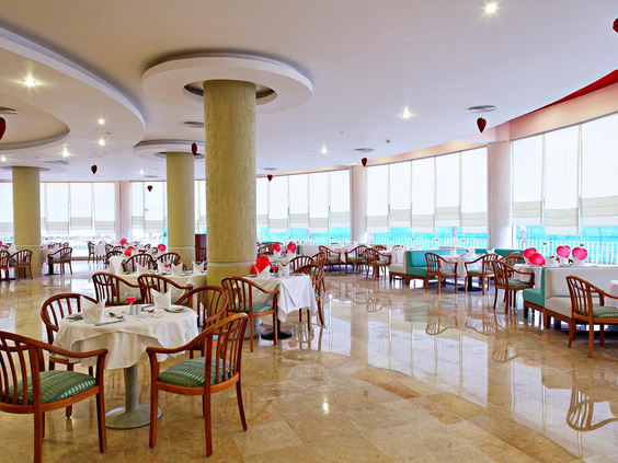Het ruime en lichte buffetrestaurant van Three Corners Sunny Beach Resort met gedekte tafels.
