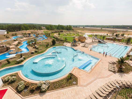 Luchtfoto van de waterspeeltuin in het buitengedeelte AMAZONIA van Tropical Islands, met ondiepe baden, fonteinen en speeltoestellen voor jonge kinderen.