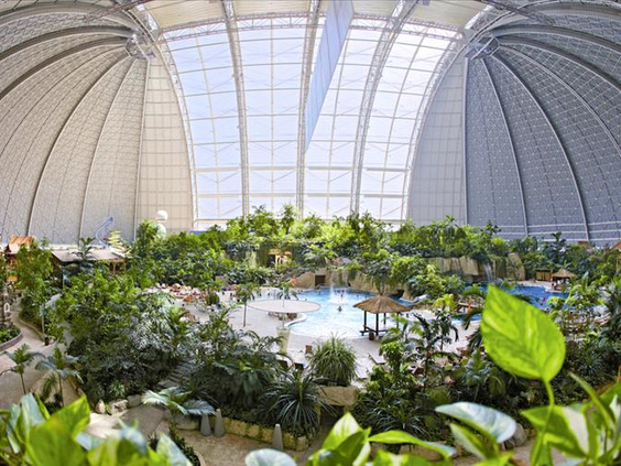 Weids overzicht van het immense indoor regenwoud in Tropical Islands, met duizenden tropische planten en bomen onder de gigantische koepel.