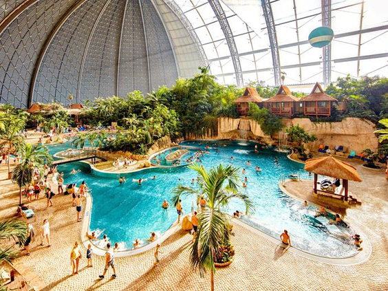 Overzicht van de 'Tropical Sea', het enorme zwembad met een 200 meter lang zandstrand, palmbomen en badgasten in het hart van Tropical Islands.