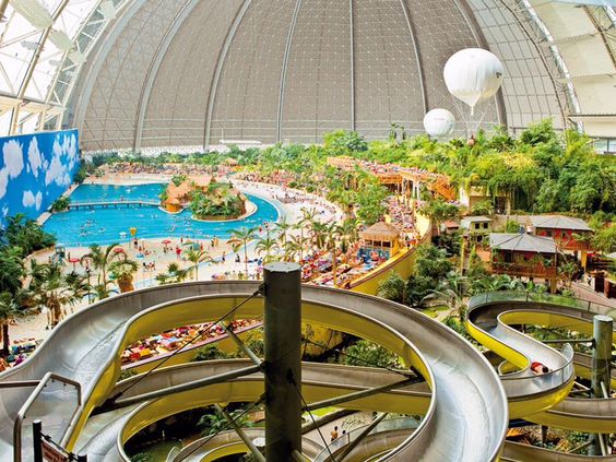 Overzicht van de 27 meter hoge glijbaantoren in het subtropische zwemparadijs van Tropical Islands, met uitzicht op de Tropical Sea en de enorme koepel.