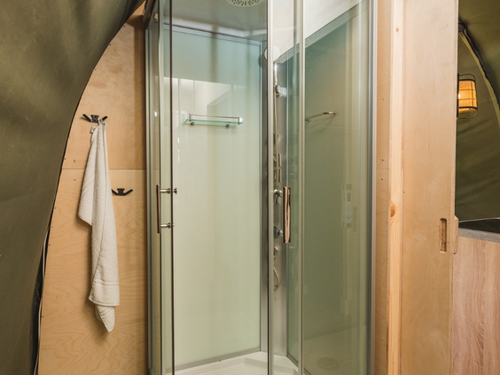 De moderne badkamer in een lodge met een comfortabele douchecabine, voor het gemak van een eigen badkamer tijdens het kamperen.