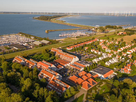 Luchtfoto van Vakantiepark Aquadelta, prachtig gelegen aan het Grevelingenmeer in Bruinisse, Zeeland, met de haven en vakantiehuizen.