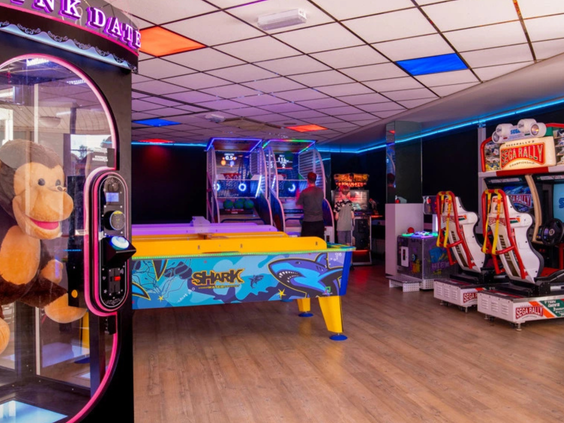 De kleurrijke gamehal en arcade op Vakantiepark Aquadelta met airhockey, een grijpmachine en diverse racegames voor kinderen.