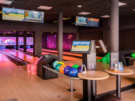 De moderne bowlingbanen van Vakantiepark Aquadelta, compleet met kleurrijke bowlingballen en digitale scoreborden.
