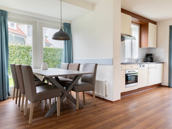 De lichte en moderne eethoek en keuken in een van de vakantiehuizen op Vakantiepark Aquadelta.